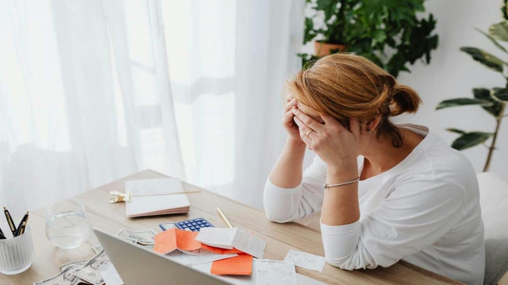 A woman looking frustrated while budgeting