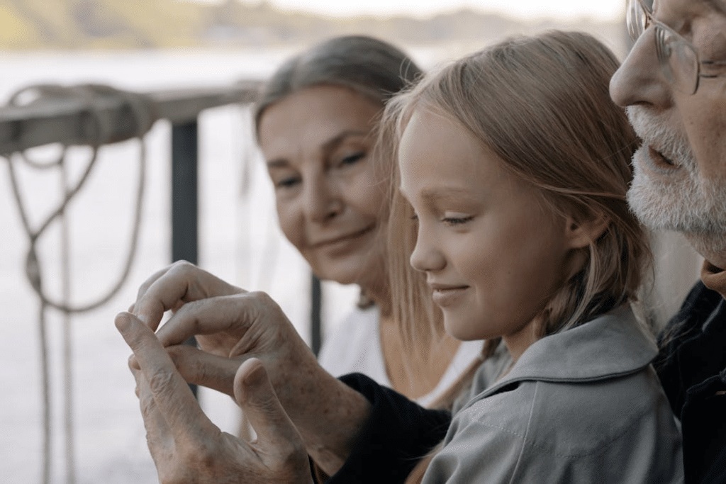 Girl in Gray Long Sleeve Shirt Smiling with her Grandparents