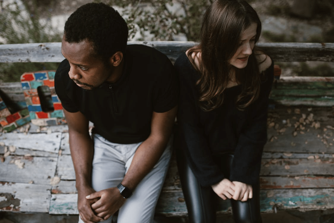 Upset couple sitting on park bench