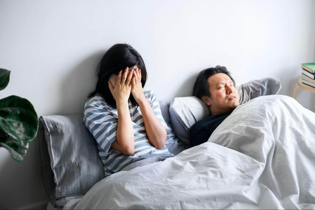 A man sleeping and a woman covering her face