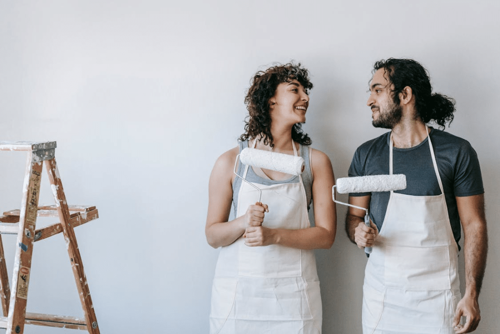 A couple holding paint rollers