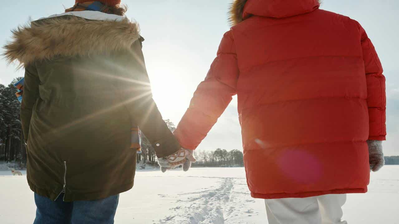 A couple holding hands while walking 