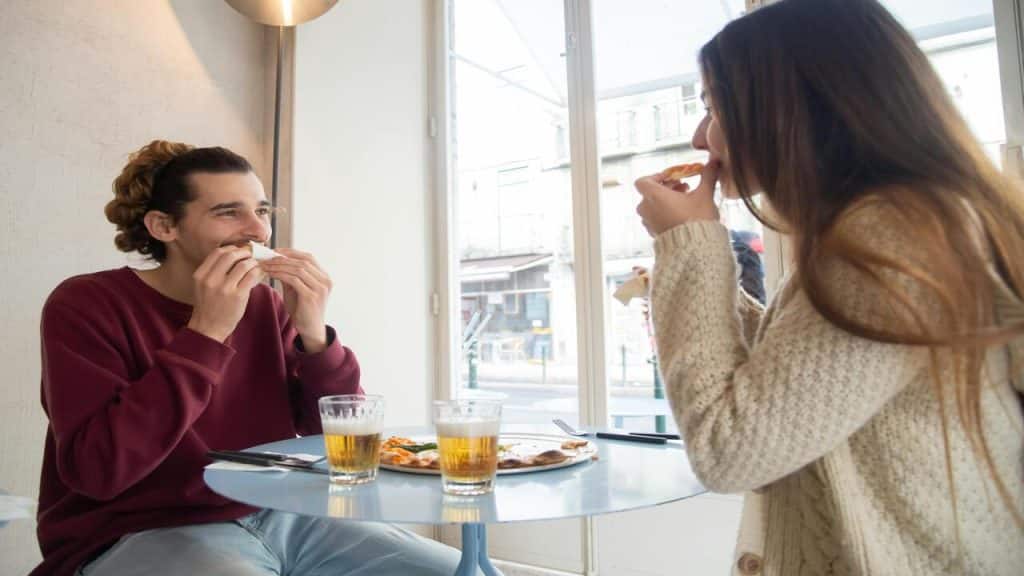 A couple talking over pizza