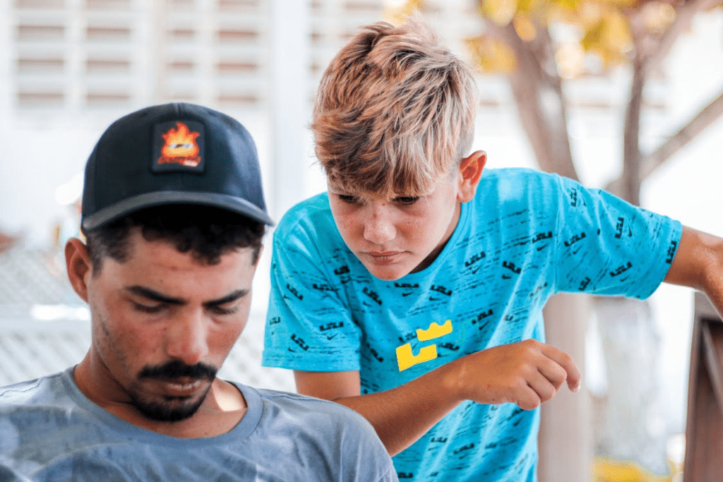 Teenager Boy Looking over his Father Shoulder