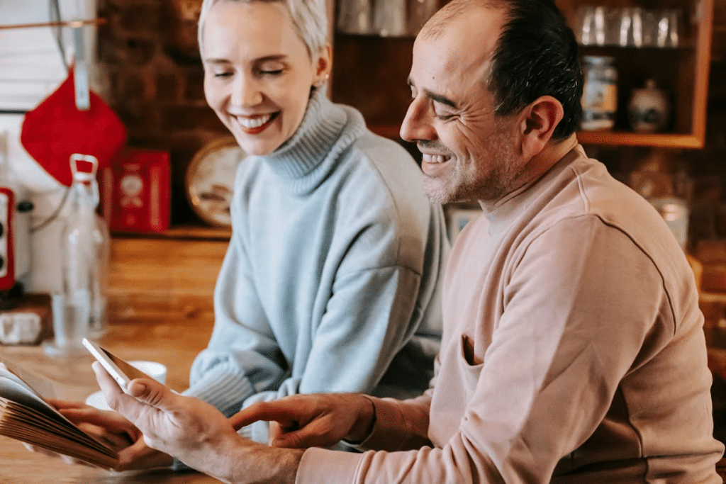 A couple smiling while looking at the tablet