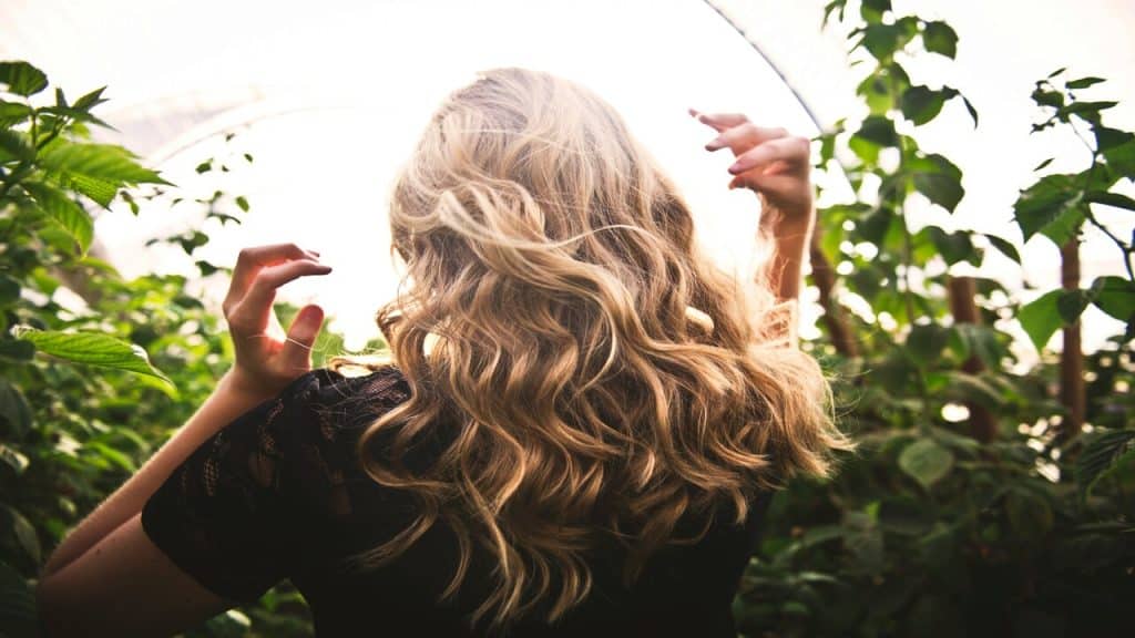 A woman about to touch her hair 