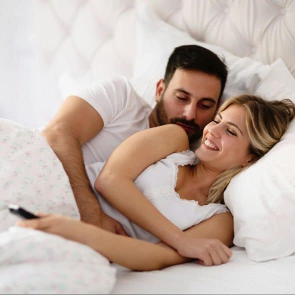A man and woman at the bed