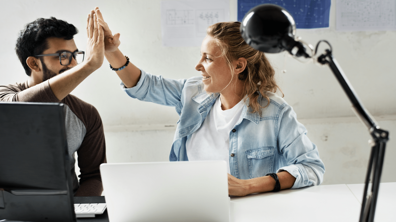 Colleagues high fiving at work