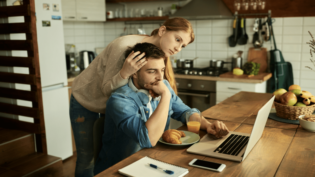 A couple looking upset while looking at a laptop