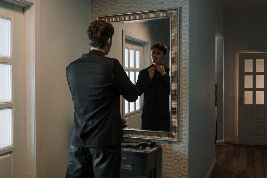 Man in Black Button Up Shirt Standing in Front of the Mirror