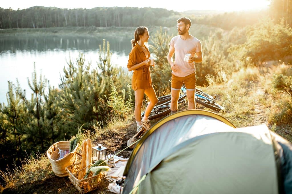 A young couple standing on the campsite.
