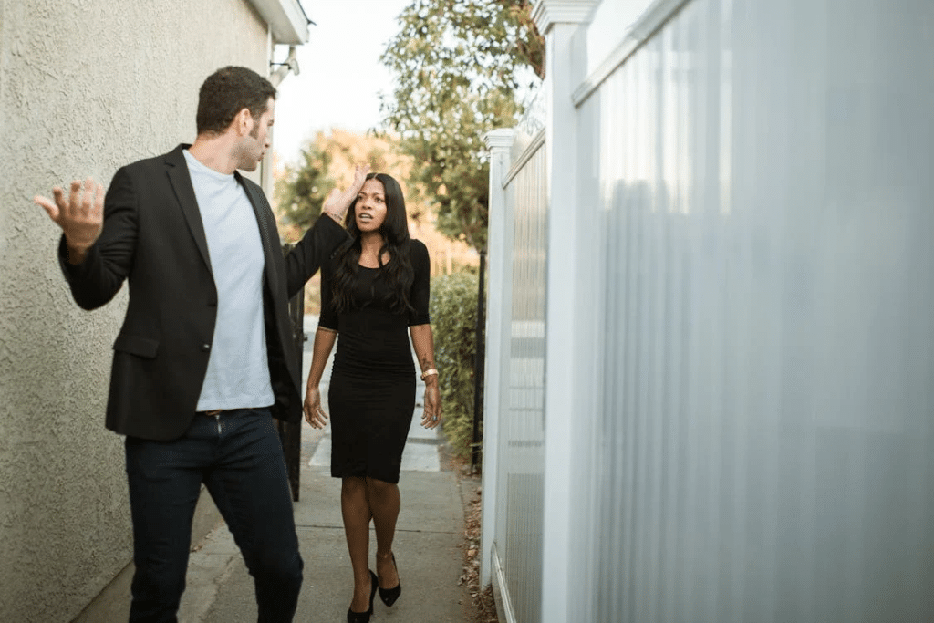 Man in Black Suit Standing Beside Woman in Black Dress