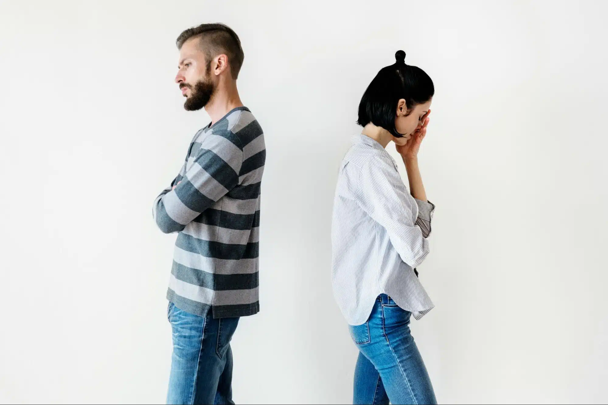 A couple standing and facing opposite from each other 