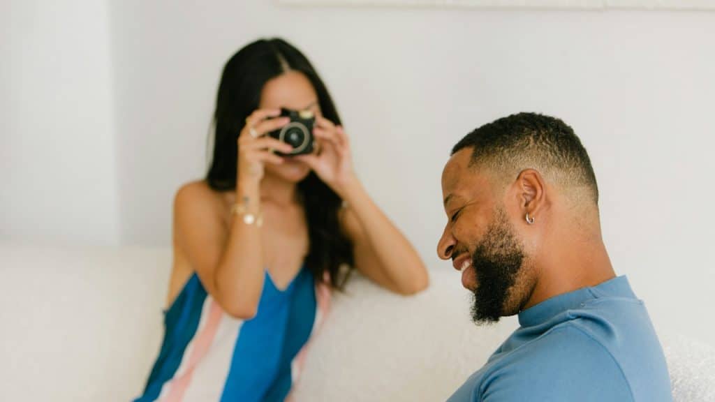 A woman taking a picture of a man with a  camera.