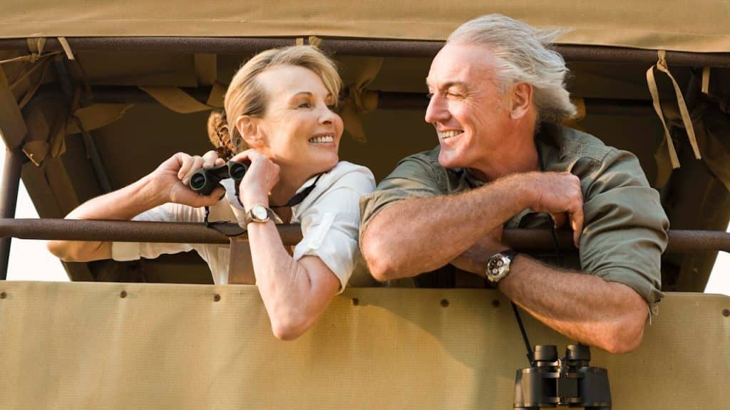 A couple smiling at each other and using binoculars.