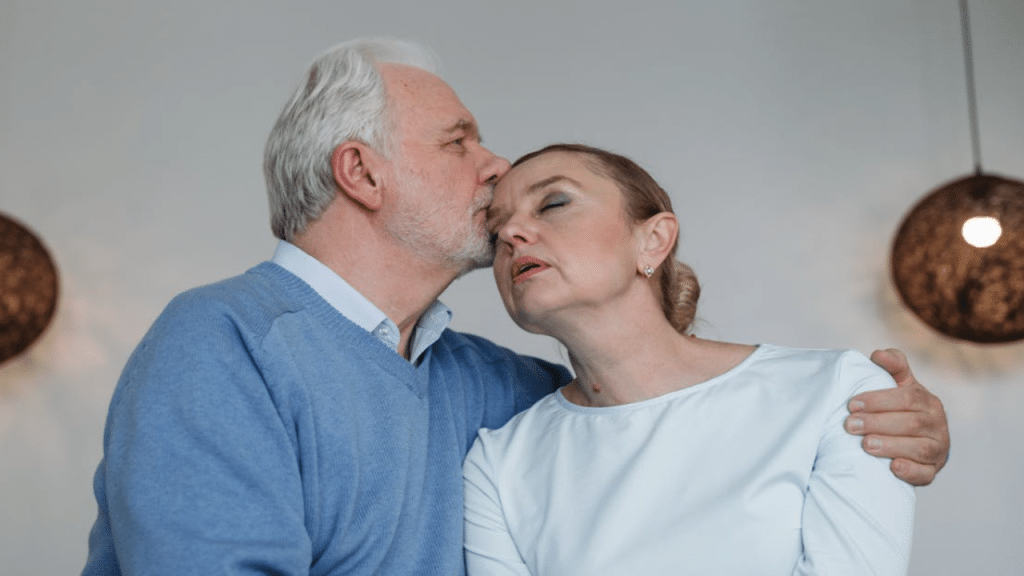 A man kissing his upset wife on the temple