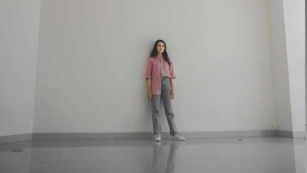 A woman standing in a room with a white wall.