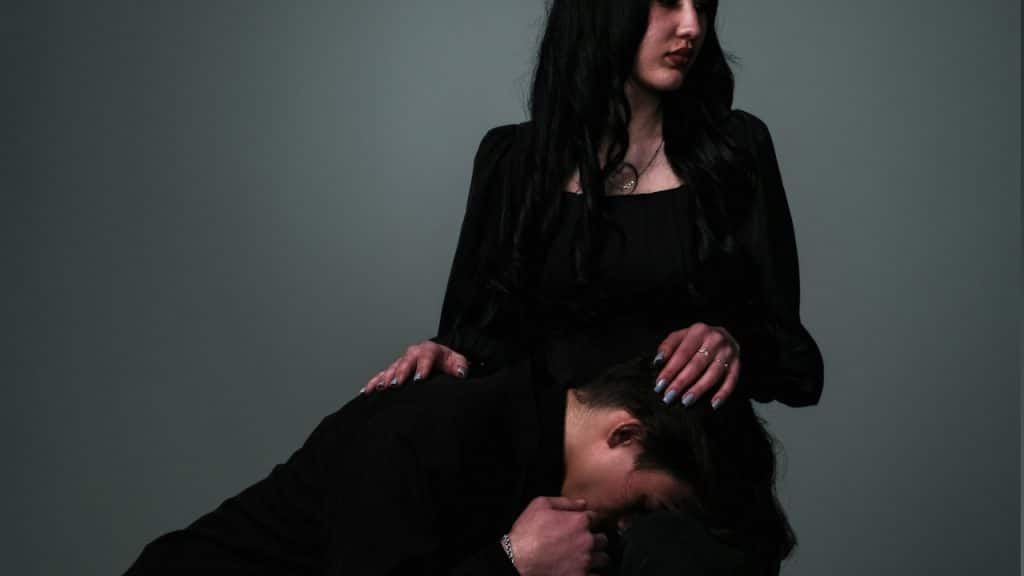A man places his head on the lap of a woman who is sitting on a chair.