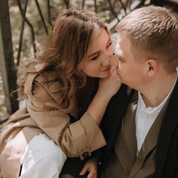 A couple sitting on a wooden bridge