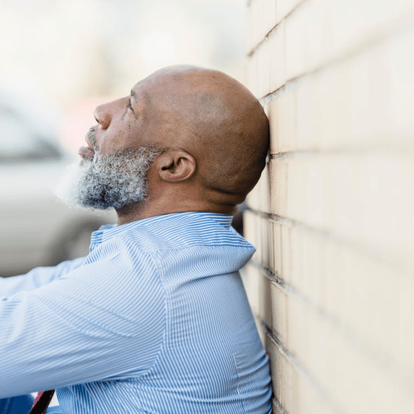 A troubled man sitting on the ground