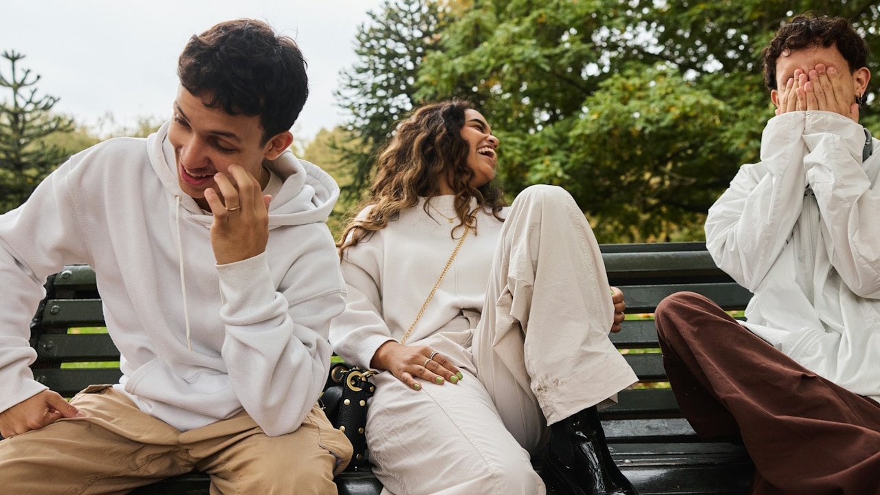 A group of people sitting in a park and laughing hard.