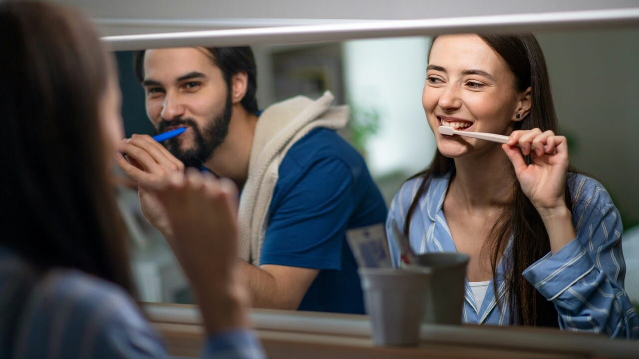A couple brushing their teeth together 