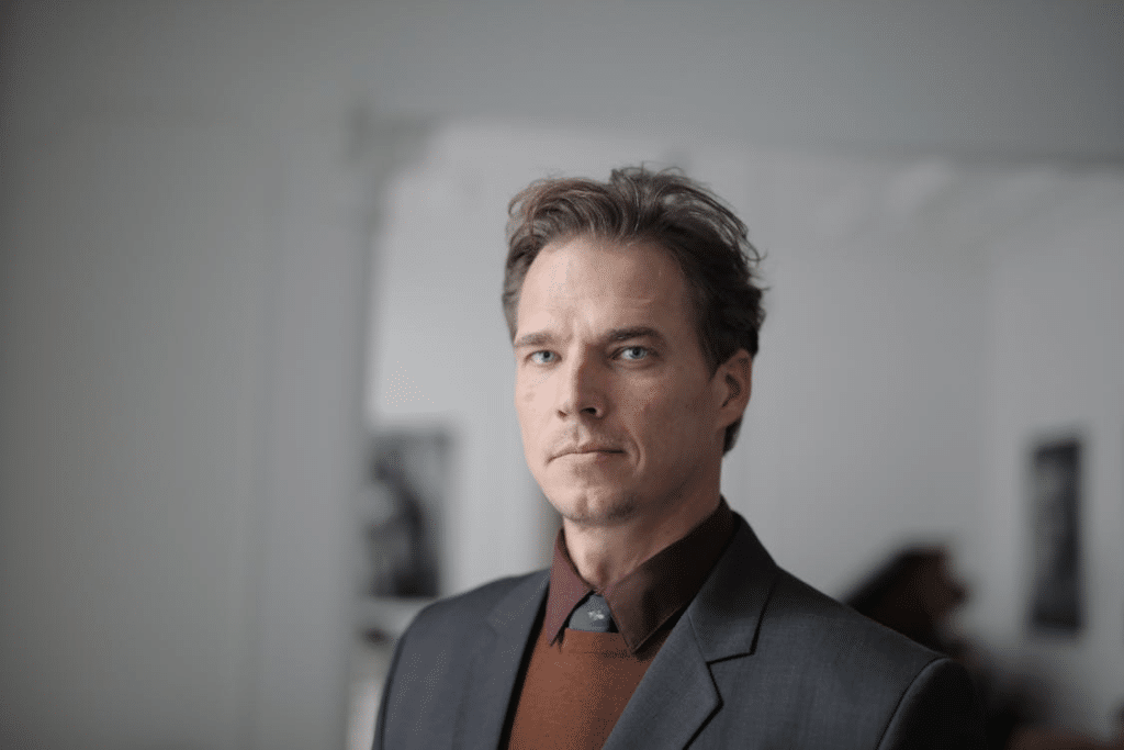 A man in formal wear with a serious look