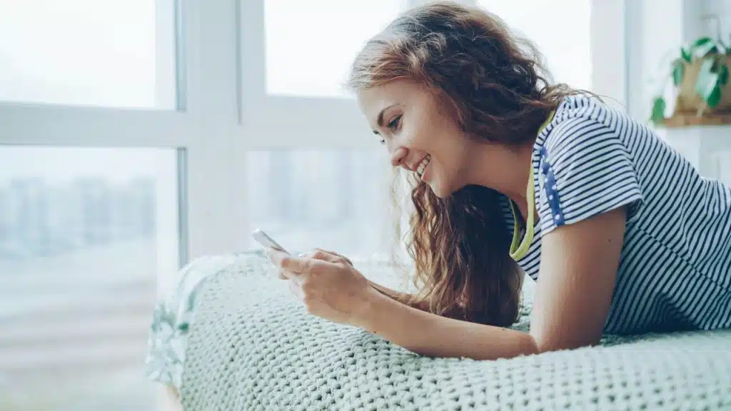 A woman smiling while texting