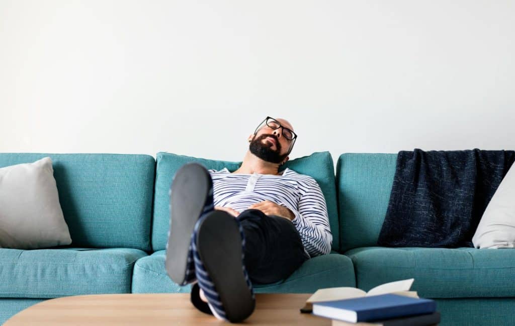 A man resting at the sofa