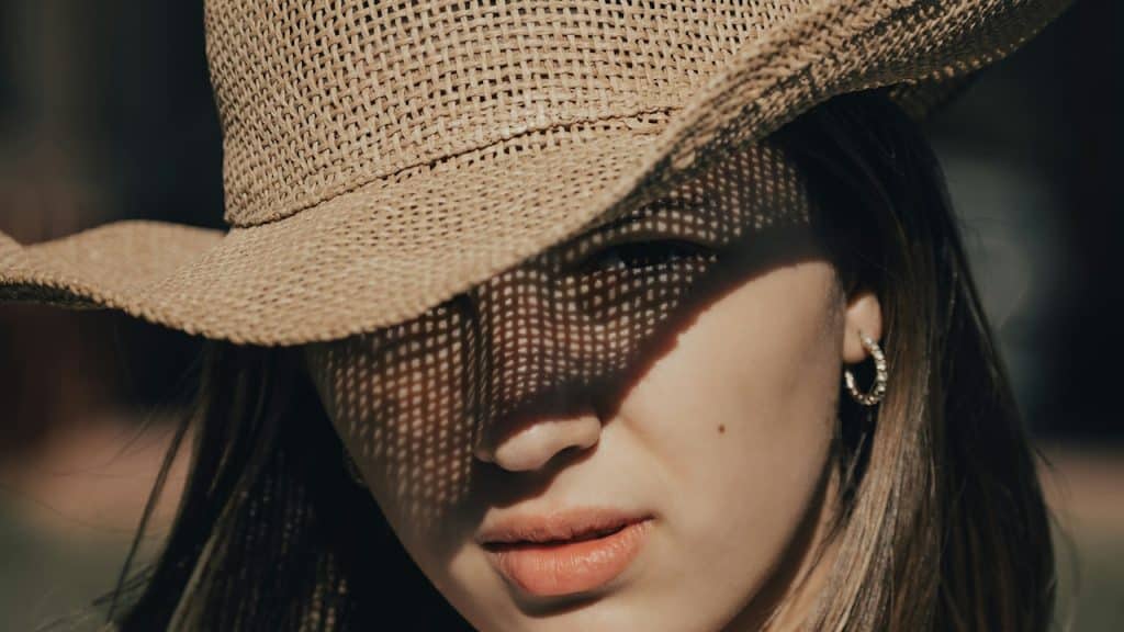 A beautiful young woman wearing a hat in the daytime.