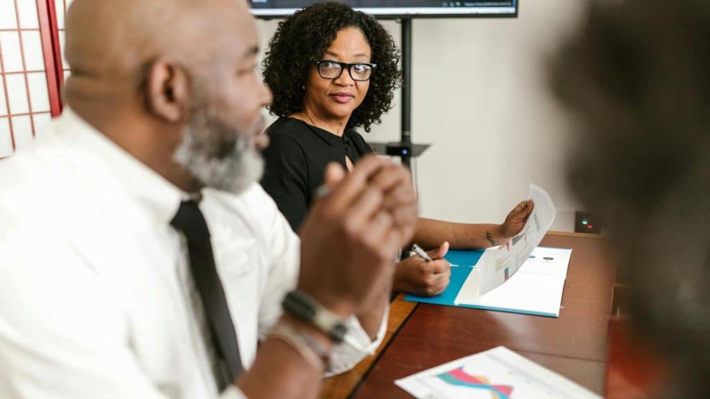 A woman listening attentively to a colleague during a meeting.