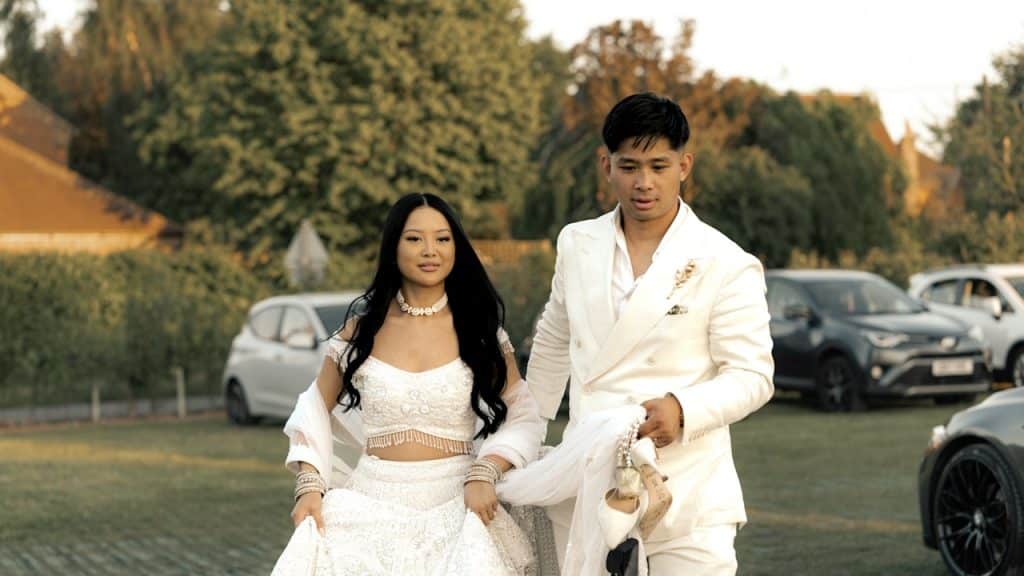 A bride and a groom in a parking lot.