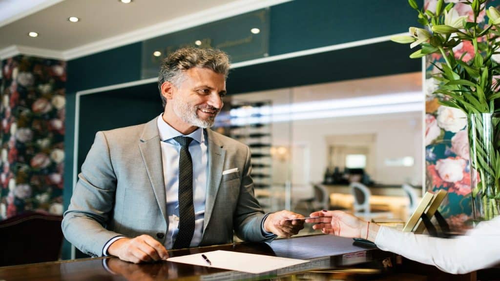 A man checking in at a hotel by himself