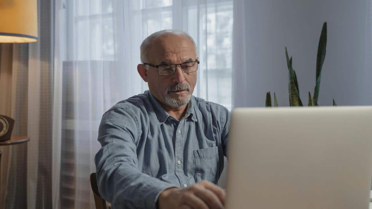 A man using a laptop at a desk.