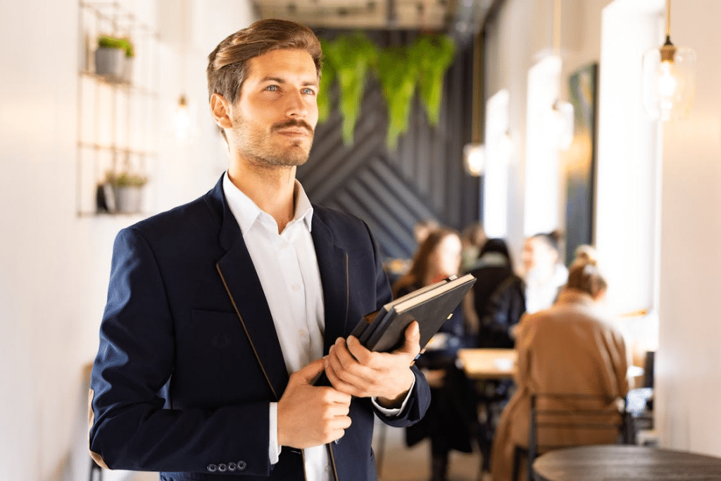 A Man in Blue Suit Holding Notebooks