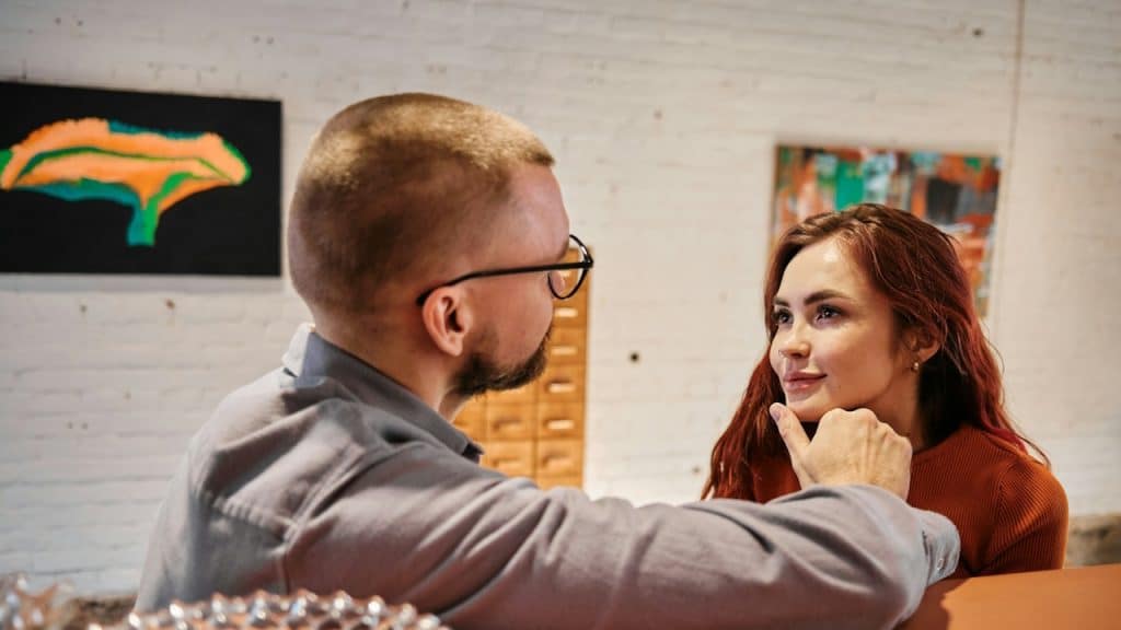A man holding the chin of a woman with love.