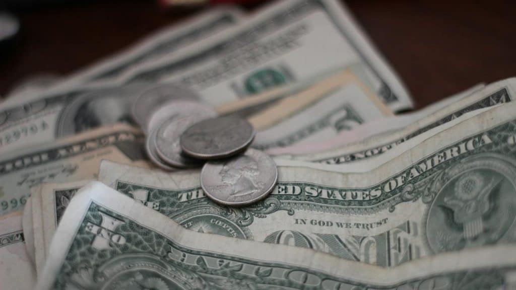 A close-up of U.S. dollar bills and coins sitting on a table.