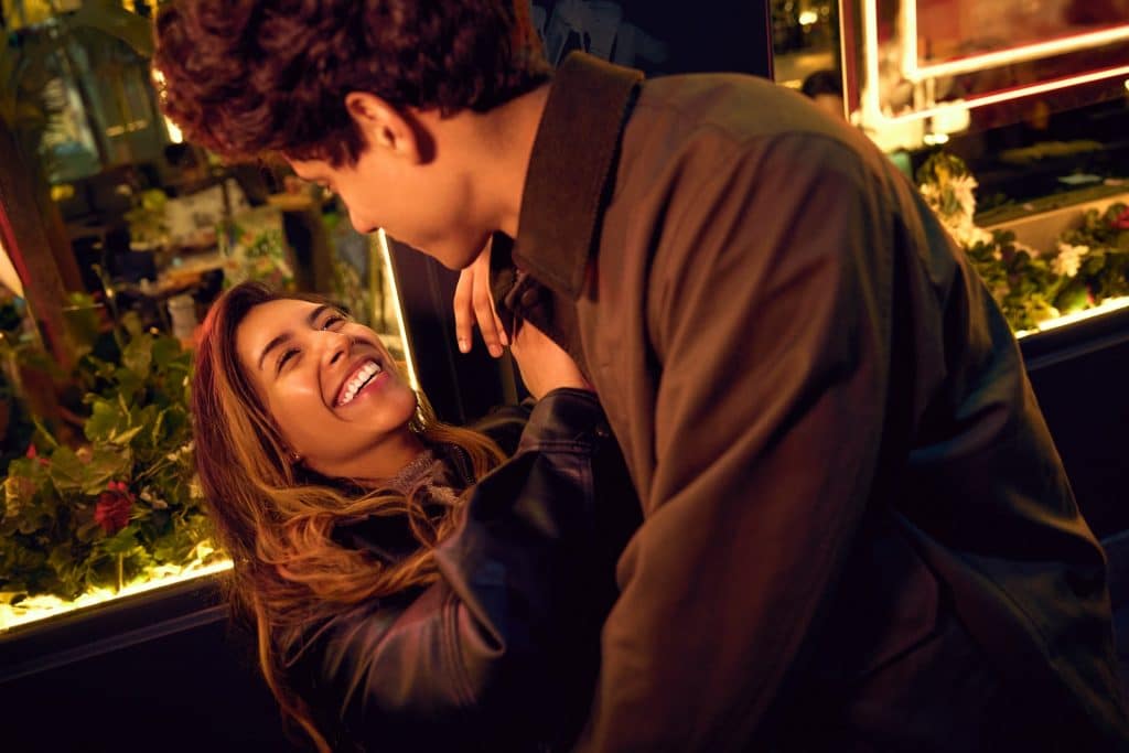 The woman is smiling brightly as she looks at the man.