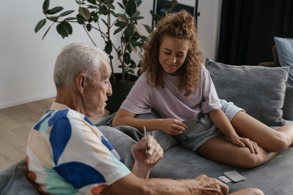 An older man playing cards with a younger woman