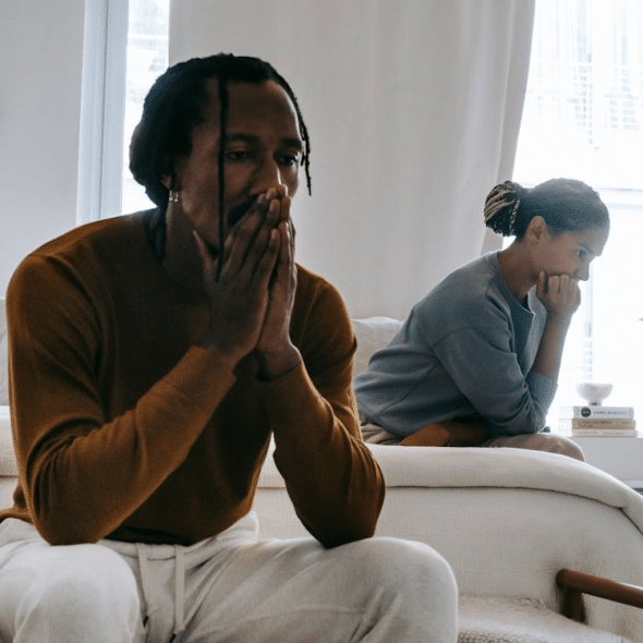 A man and a woman sitting on the bed