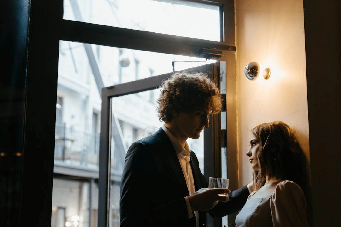 A couple standing near the window