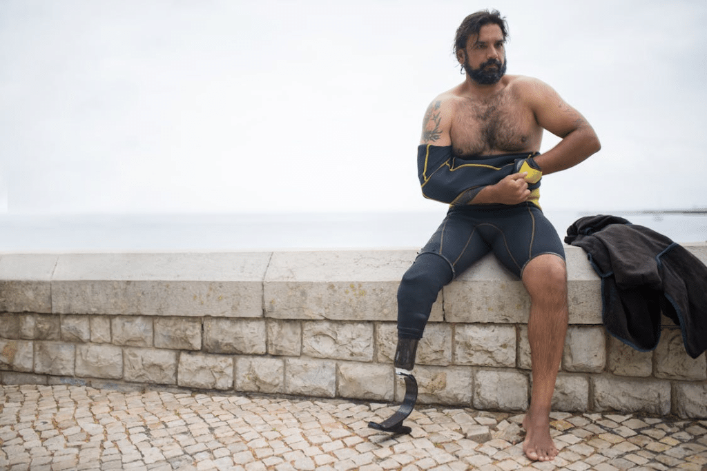 A man sitting on a ledge wearing rash guard
