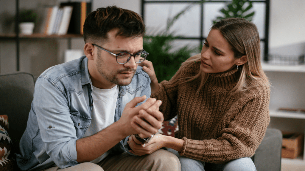 A woman comforting her sad boyfriend