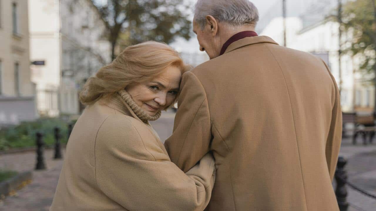 A couple walking on a sidewalk 