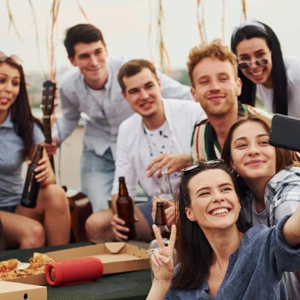 A group of friends smiling together and taking a selfie.