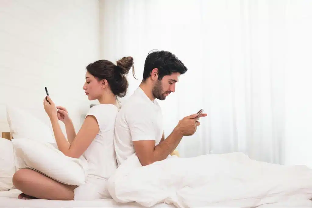 A man and woman sitting back to back