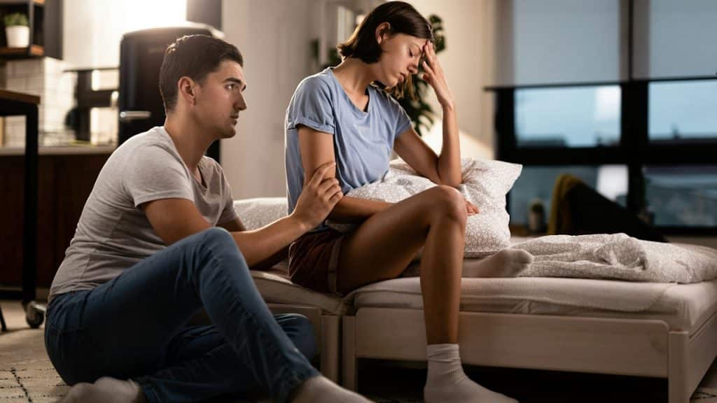 A young woman ignoring her boyfriend, who is trying to apologize to her after a quarrel.