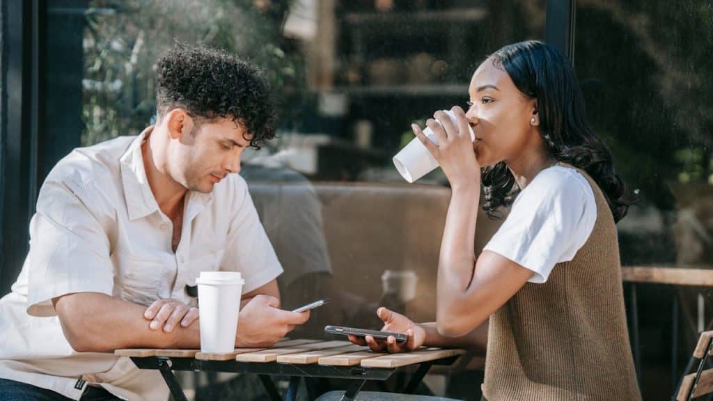 A man and a woman sitting at an outdoor cafe table.