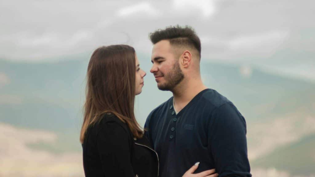 A man and a woman holding each other outdoors.
