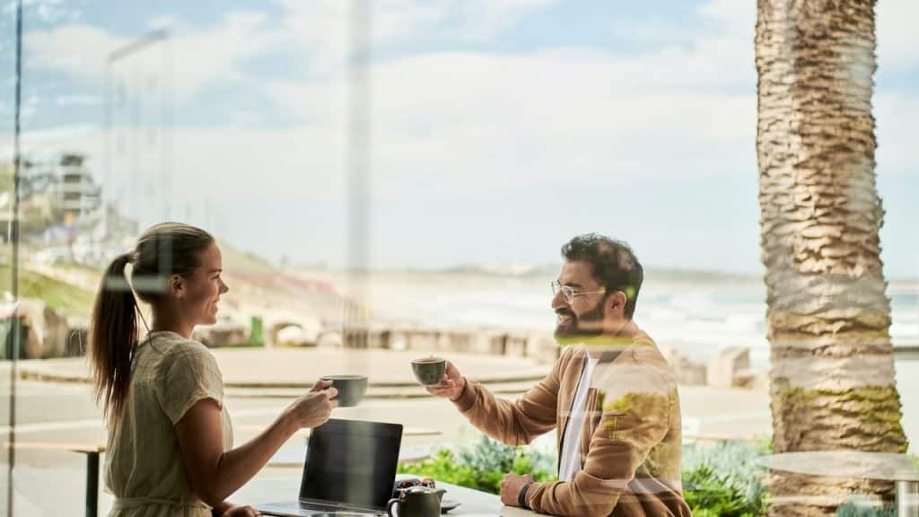 A couple on a date having coffee outside at a table.